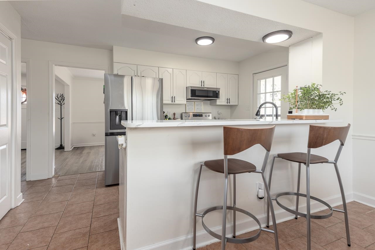 2835 McVay Trail Drive Memphis, TN 38119 - Photo 17 of 29 Kitchen featuring a breakfast bar, white cabinetry, appliances with stainless steel finishes, and kitchen peninsula