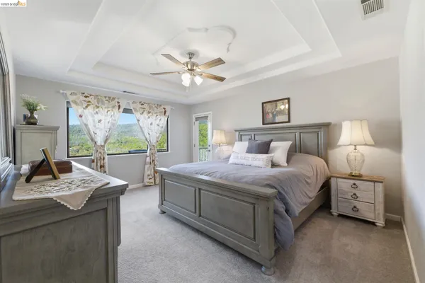a bedroom with a large bed and a mirror on dresser