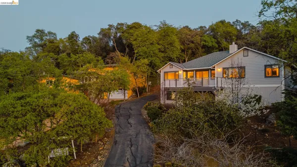 an aerial view of a house with a yard and wooden fence