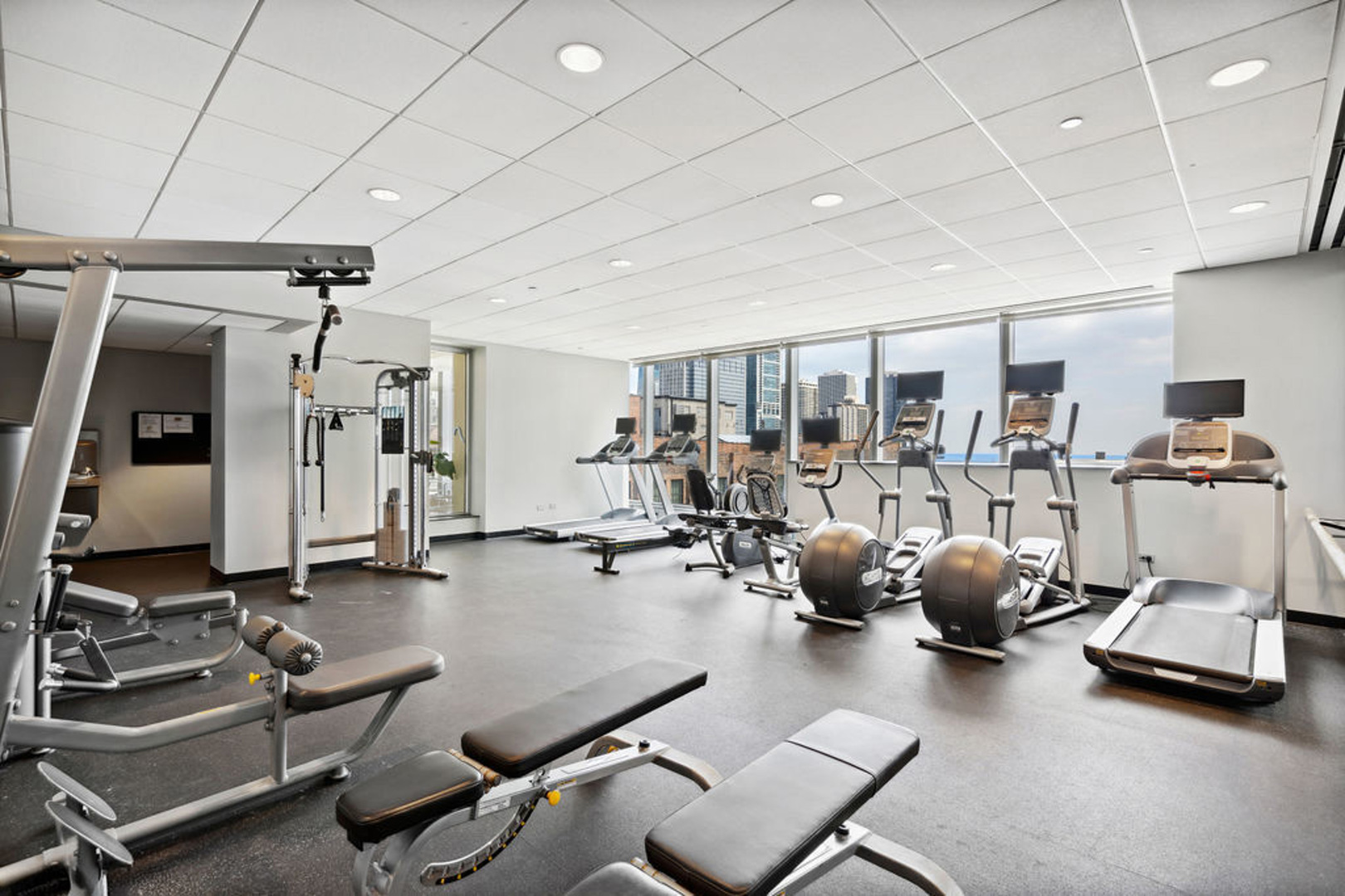 60 East Monroe Street, Unit 2307 Chicago, IL 60603 - Photo 23 of 27 a room with gym equipment and a table