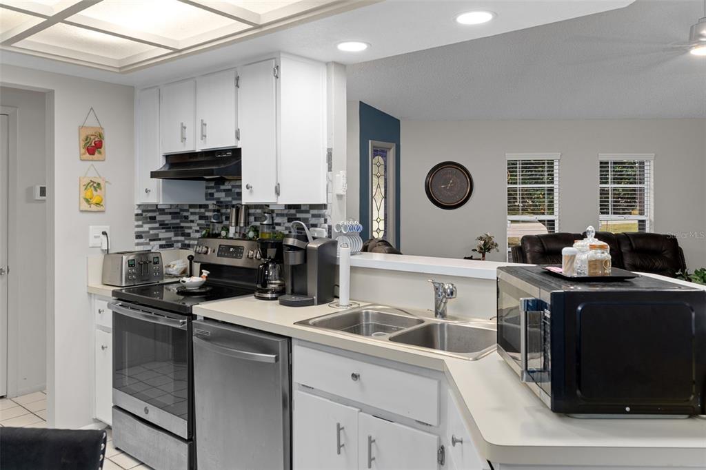4355 Goldcoast Avenue Spring Hill, FL 34609 - Photo 13 of 30 a kitchen with stainless steel appliances granite countertop a sink stove refrigerator and cabinets