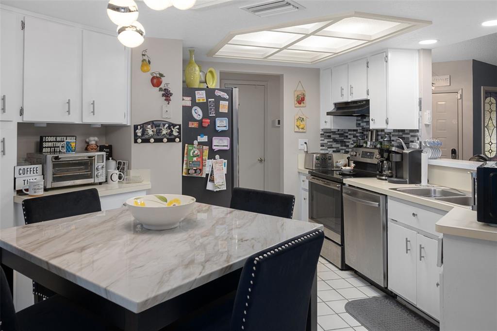 4355 Goldcoast Avenue Spring Hill, FL 34609 - Photo 14 of 30 a kitchen with a sink a stove and chairs