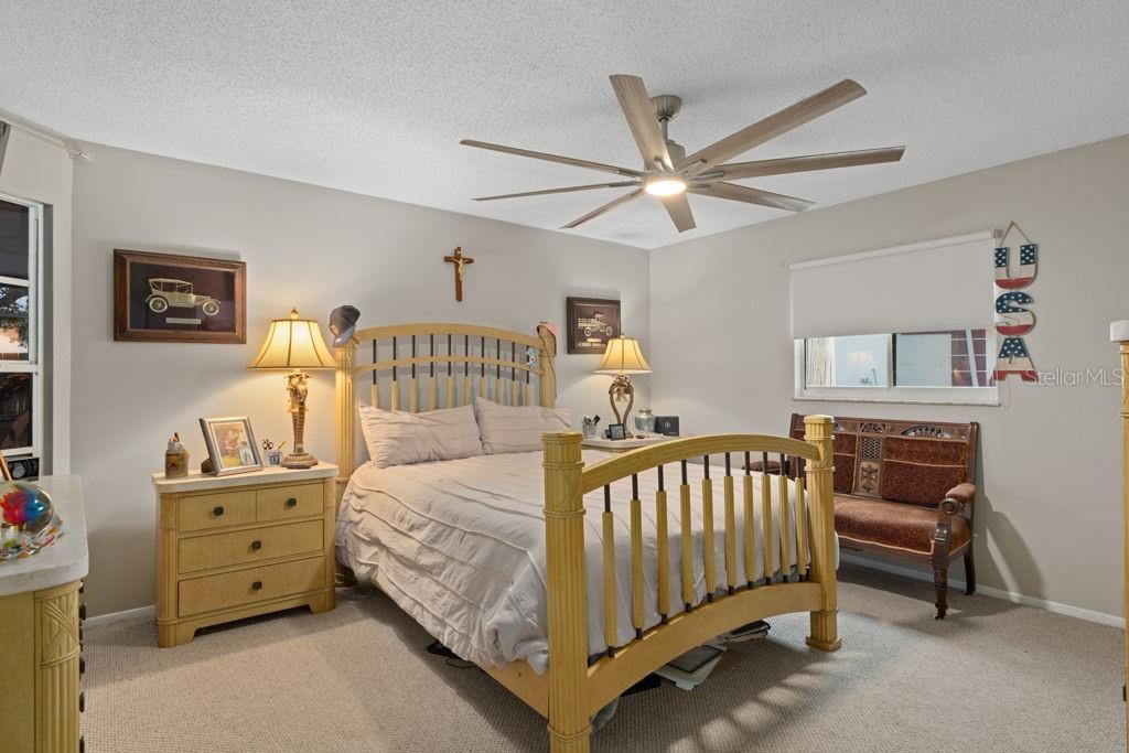 4355 Goldcoast Avenue Spring Hill, FL 34609 - Photo 15 of 30 a bedroom with a bed and a chandelier