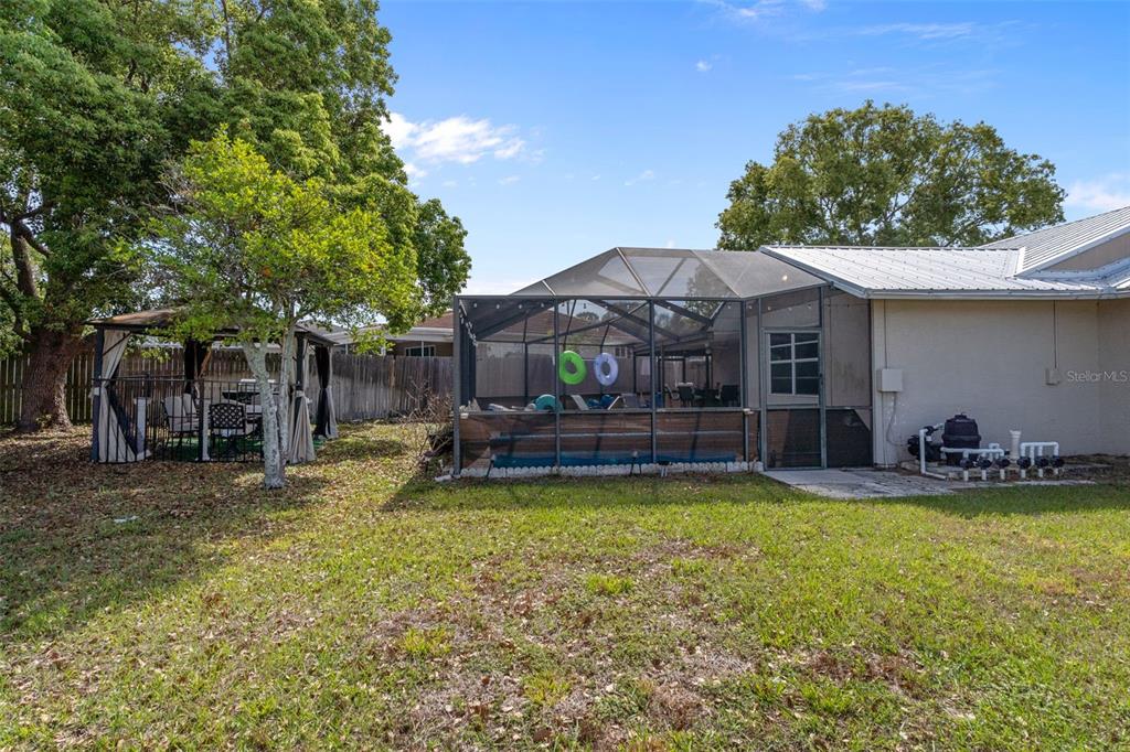 4355 Goldcoast Avenue Spring Hill, FL 34609 - Photo 28 of 30 a view of a swimming pool with lawn chairs under an umbrella