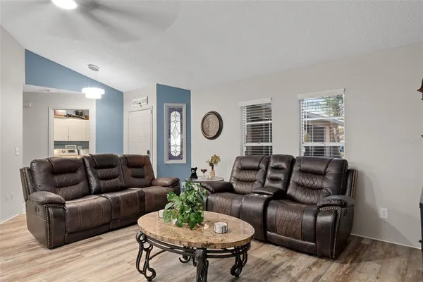 a living room with furniture potted plant and wooden floor