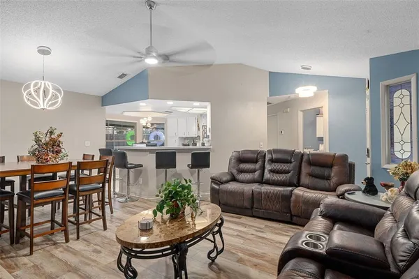 a living room with furniture a chandelier and a dining room