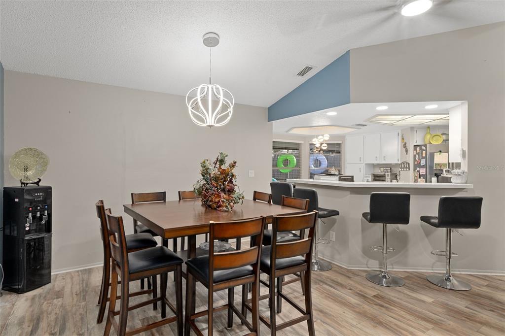 4355 Goldcoast Avenue Spring Hill, FL 34609 - Photo 10 of 30 a dining room filled chandelier and wooden floor