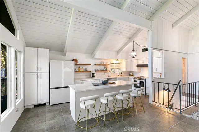 a kitchen with stainless steel appliances granite countertop a sink a stove and white cabinets