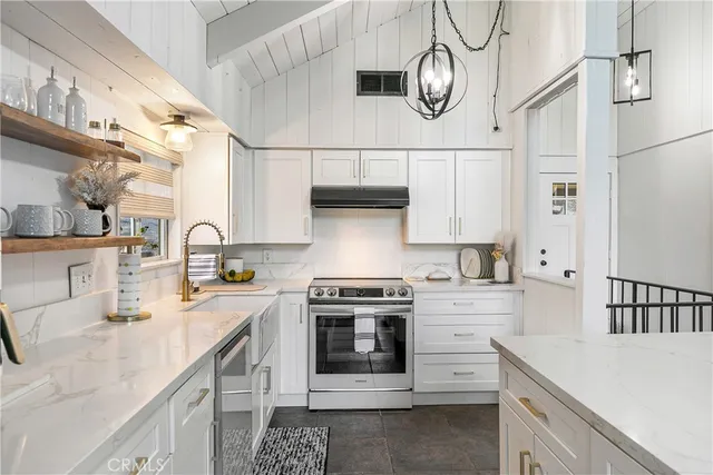 a kitchen with stainless steel appliances a sink a stove and cabinets