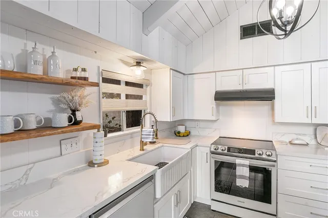 a kitchen with a sink a stove and cabinets