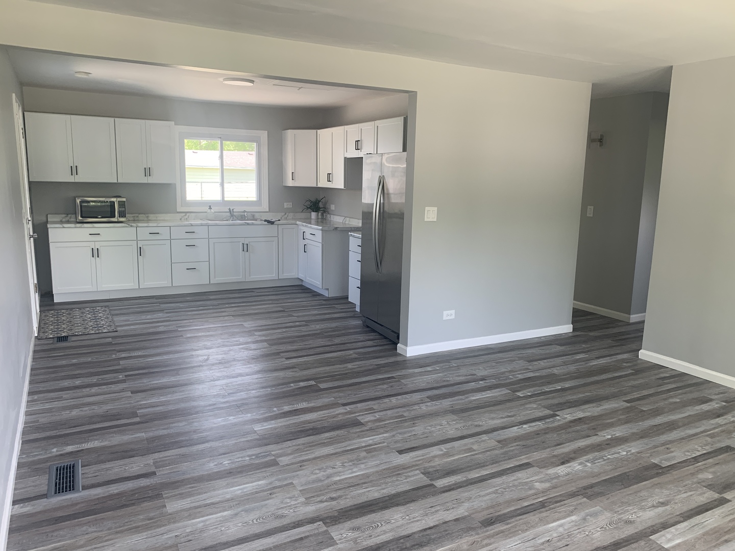 305 Tiverton Lane Steger, IL 60475 - Photo 7 of 13 a large kitchen with wooden floors and white stainless steel appliances