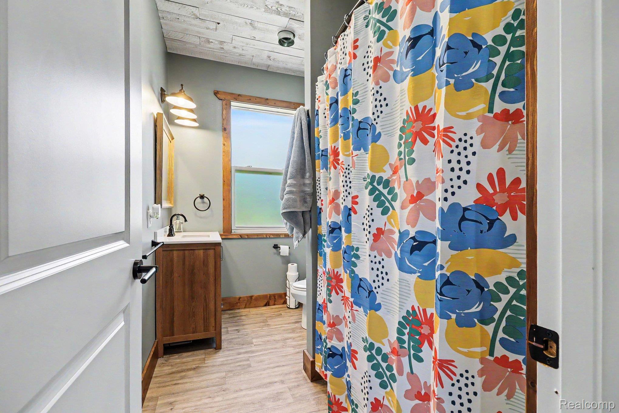 2150 East Snover Road Mayville, MI 48744 - Photo 27 of 48 Bathroom featuring a wood vanity with a white countertop, wall-mounted faucet, and a mirror with a decorative frame