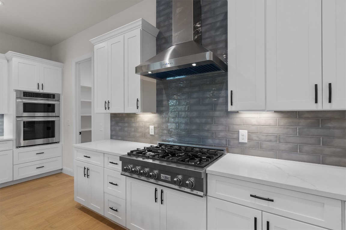 7705 Calcutta Run Drive Jonestown, TX 78645 - Photo 13 of 40 a kitchen with white cabinets and appliances
