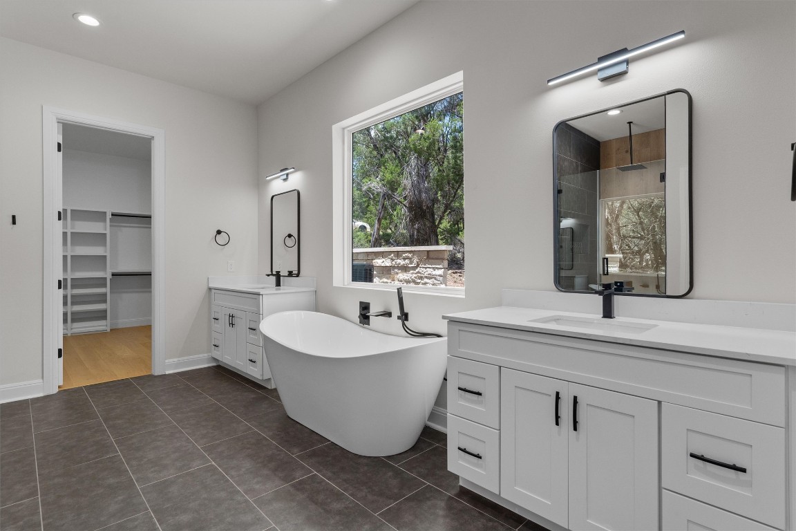 7705 Calcutta Run Drive Jonestown, TX 78645 - Photo 18 of 40 a spacious bathroom with a double vanity sink mirror and bathtub