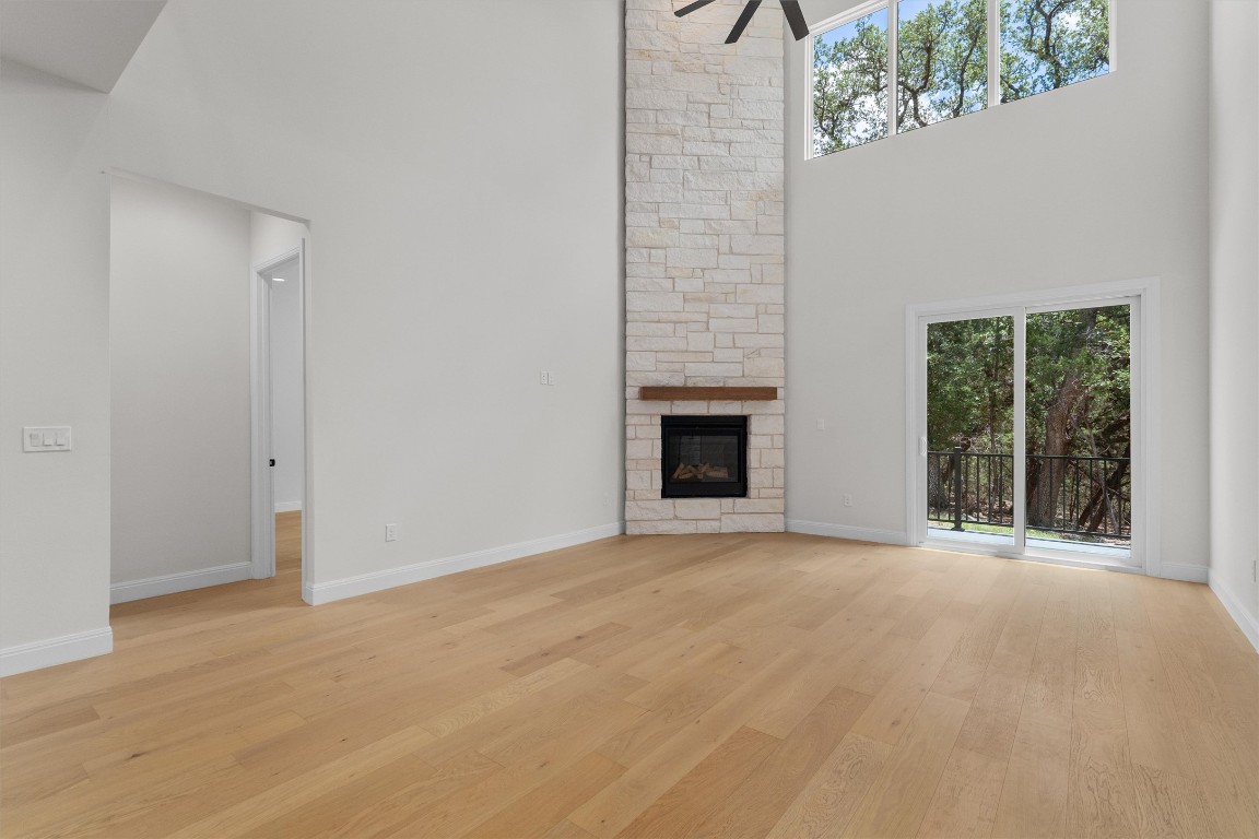 7705 Calcutta Run Drive Jonestown, TX 78645 - Photo 8 of 40 en empty room with windows and fireplace