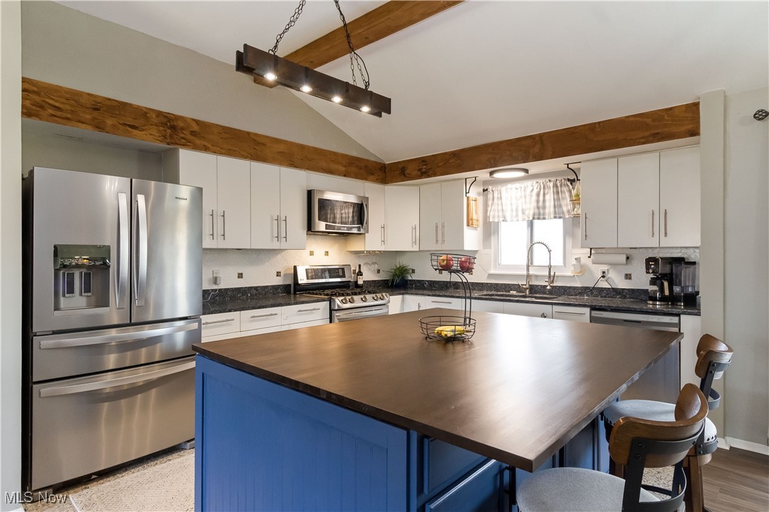 5900 Lear Nagle Road North Ridgeville, OH 44039 - Photo 7 of 35 Kitchen featuring vaulted ceiling with beams, backsplash, stainless steel appliances, and a sink
