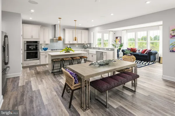 a living room with stainless steel appliances kitchen island granite countertop furniture wooden floor and a view of kitchen