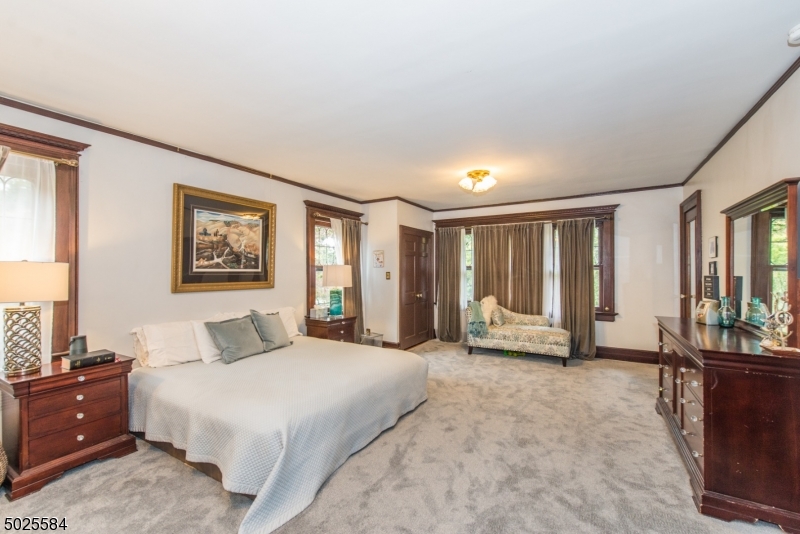 89 Ridgewood Avenue Glen Ridge, NJ 07028 - Photo 14 of 21 a spacious bedroom with a large bed and a window