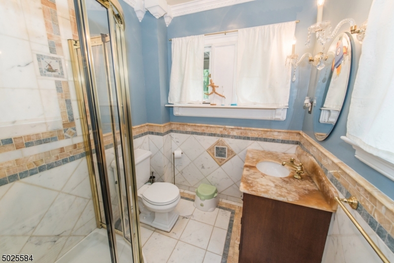 89 Ridgewood Avenue Glen Ridge, NJ 07028 - Photo 17 of 21 a bathroom with a granite countertop sink and a mirror