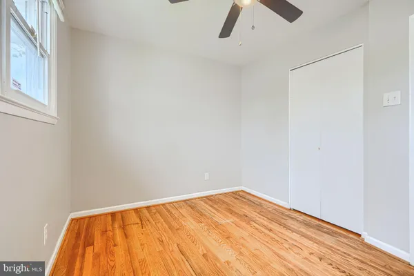 a view of room with a ceiling fan and wooden floor