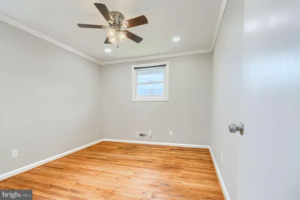 an empty room with a window and a ceiling fan