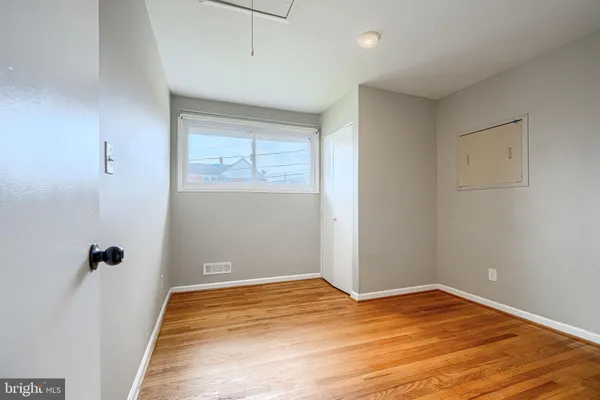 a view of empty room with wooden floor