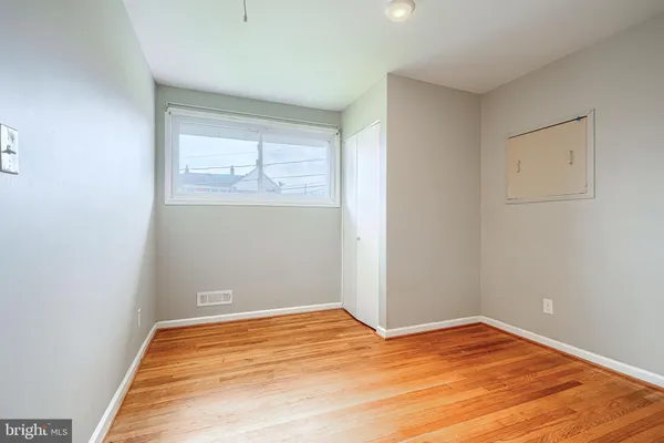 a view of empty room with wooden floor