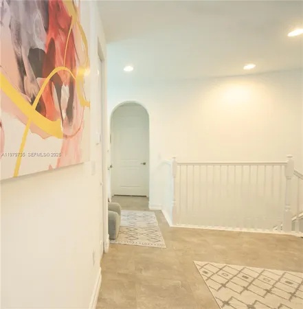 a view of a hallway with windows and furniture