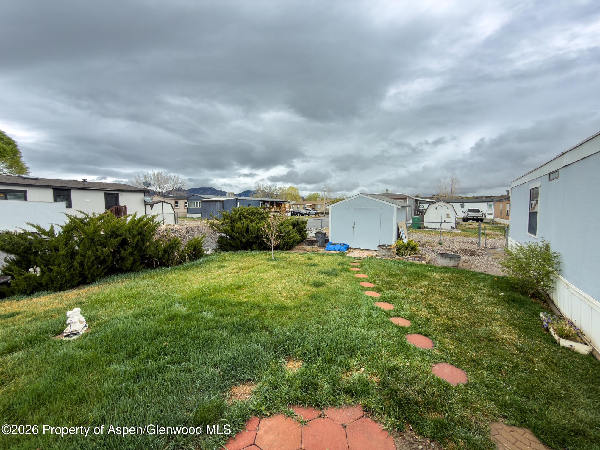 200 West 20th Street, Unit B17 Rifle, CO 81650 - Photo 11 of 12 a backyard of a house with plants and large trees