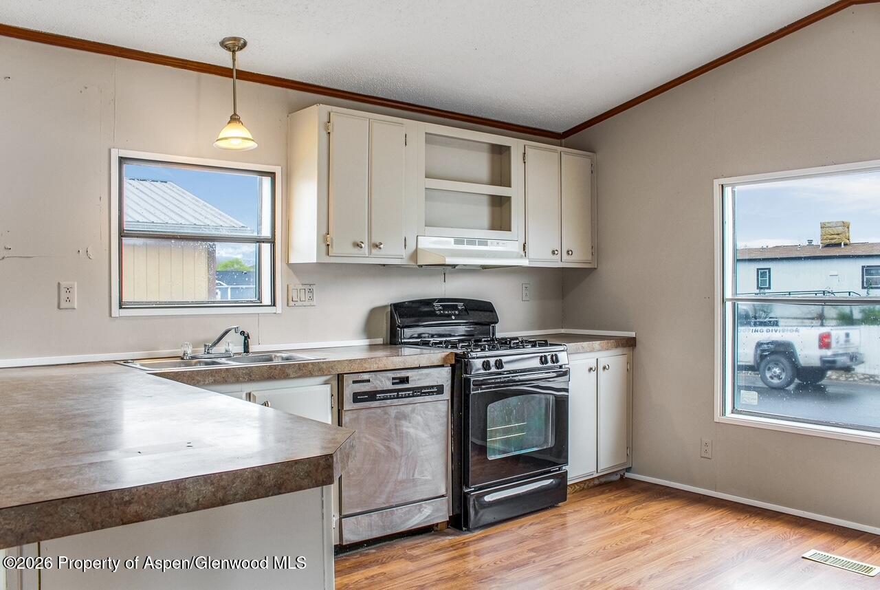 200 West 20th Street, Unit B17 Rifle, CO 81650 - Photo 3 of 12 a kitchen with stainless steel appliances granite countertop a stove a sink and a microwave