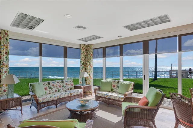 a view of a livingroom with lounge chair and a large window