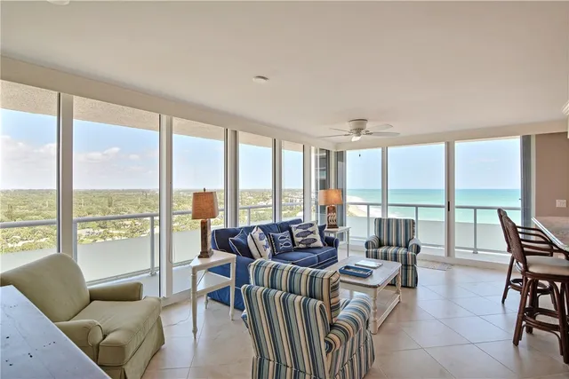 a living room with furniture and floor to ceiling windows