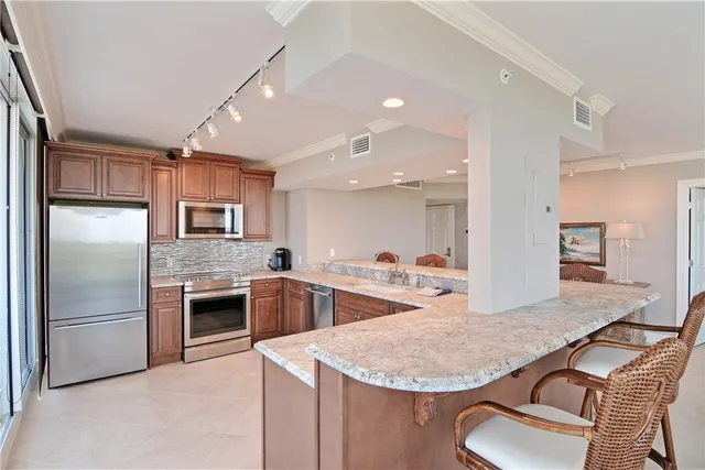a kitchen with stainless steel appliances granite countertop a sink refrigerator and cabinets