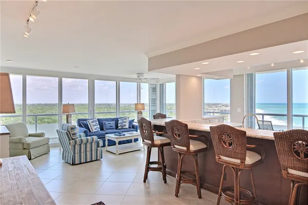 a living room with furniture and floor to ceiling windows
