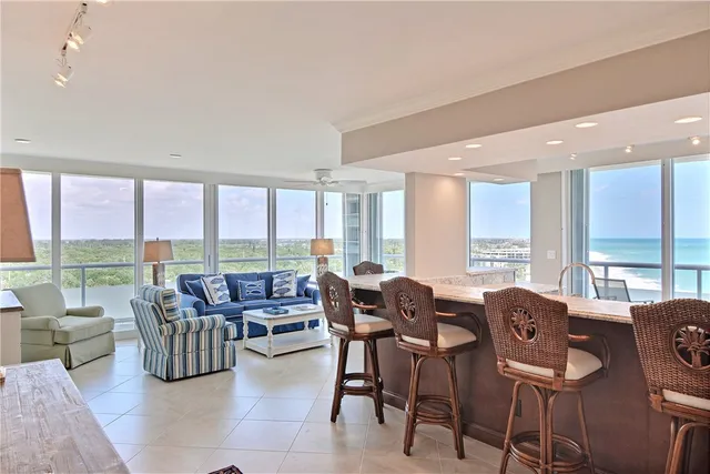 a living room with furniture and floor to ceiling windows