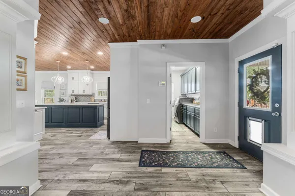 a kitchen with granite countertop a sink stove a refrigerator and white cabinets with wooden floor