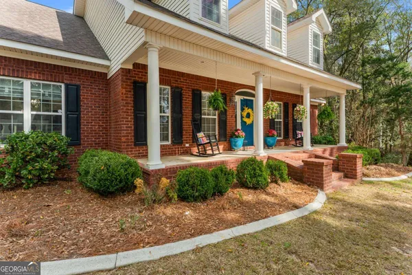 front view of a brick house with a yard