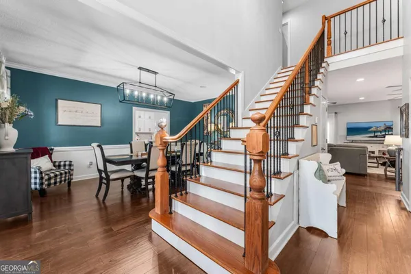 a view of a hallway with wooden floor and staircase