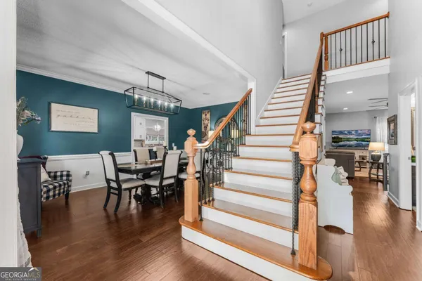 a view of a hallway with wooden floor and staircase