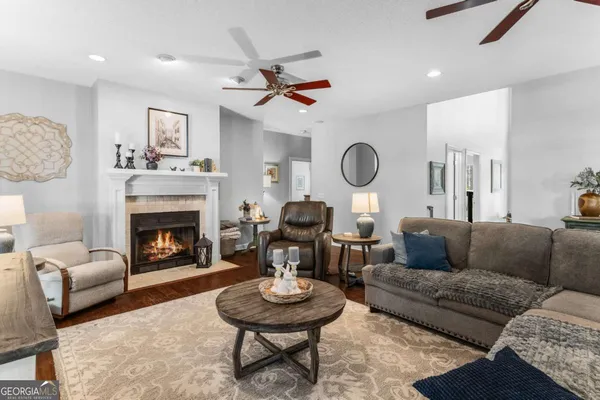 a living room with furniture a rug kitchen view and a window
