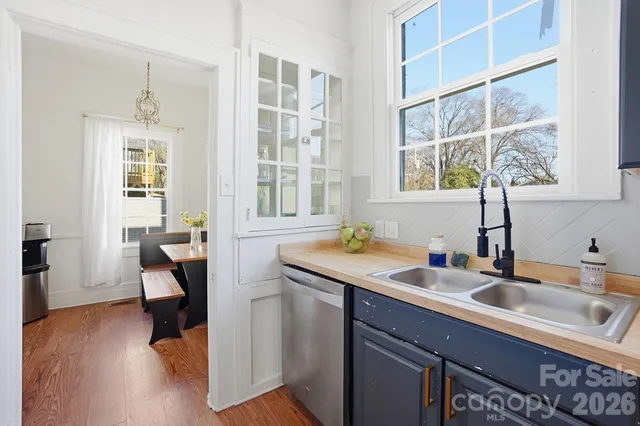 a view of a kitchen island a sink and wooden floor