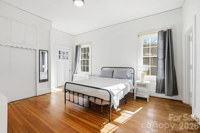 a bedroom with a bed wooden floor and window