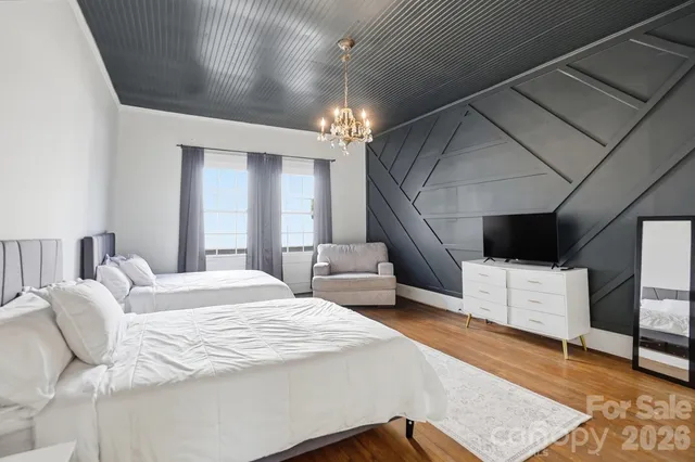 a bedroom with a large bed and a chandelier