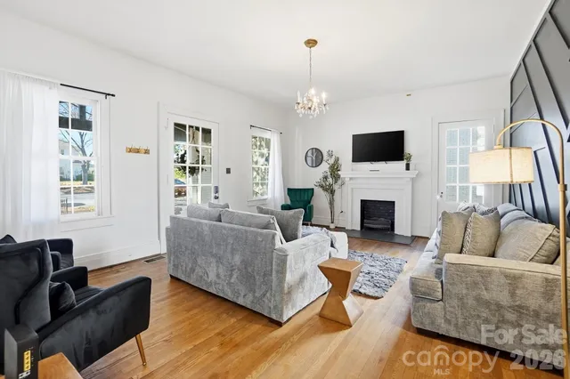 a living room with furniture a flat screen tv and a fireplace