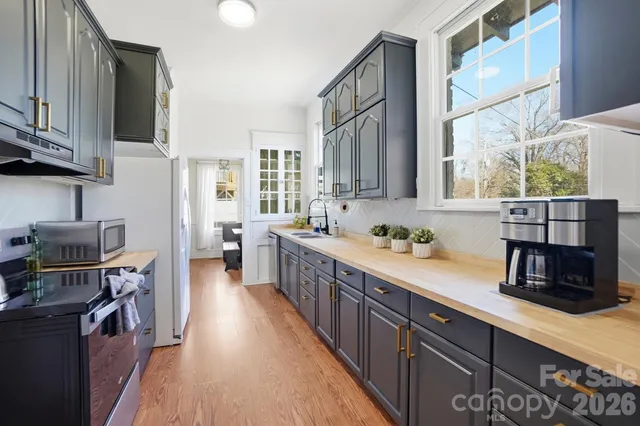 a kitchen with stainless steel appliances a sink dishwasher a refrigerator a stove and wooden cabinets