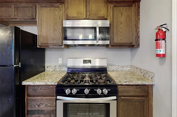 a kitchen with stainless steel appliances granite countertop a stove and a microwave