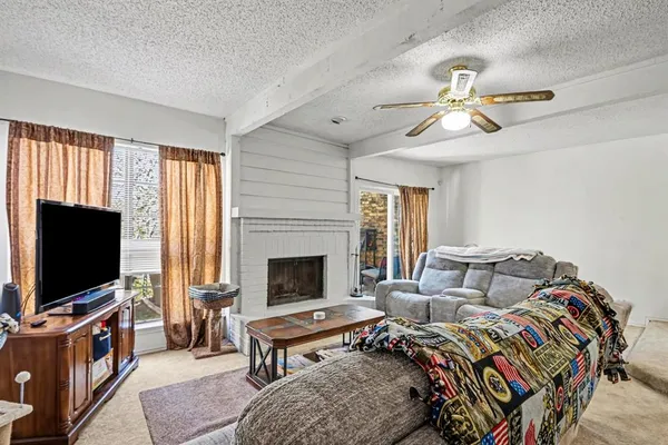 a living room with furniture a flat screen tv and a fireplace