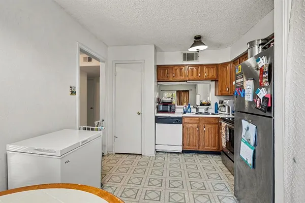 a open kitchen with stainless steel appliances granite countertop a sink and a refrigerator