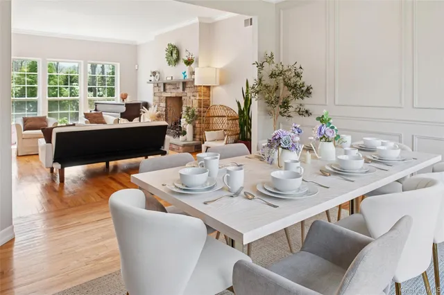 a dining room with furniture large windows and wooden floor