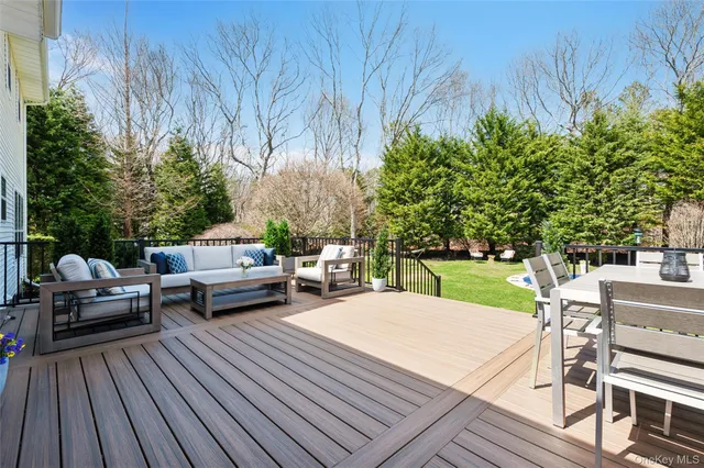 a view of a patio with dining table and chairs with wooden floor and fence